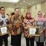 Ketua KI Pusat, Gede Narayana saat memberikan piagam penghargaan kepada Gubernur Jawa Timur Khofifah Indar Parawansa yang disaksikan oleh Wakil Presiden RI, Prof. Dr. K.H. Ma