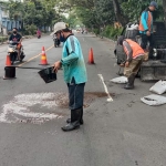 Petugas dari Dinas PUPR Kota Kediri saat memperbaiki jalan rusak. foto: ist.