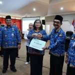 Pj Wali Kota Kediri saat menyerahkan SK Pensiun secara simbolis kepada Kepala Diskominfo Kota Kediri, Apip Permana. Foto: Ist