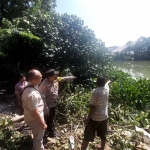 Polsek Karangpilang saat meninjau lokasi bunuh diri korban di Sungai Brantas, Surabaya.