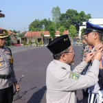 Pj Bupati Pasuruan Andriyanto saat memasang pita kepada personel yang akan bertugas dalam operasi lilin 2023. 