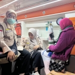 Tim dokter PPIH 2026, Atika Nithasari (kiri) bersama Febby saat memberikan pertolongan pertama kepada Tjutju Kurniasih. Foto: MCH 2026.