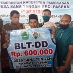 Kades Sanatengah Jailani Fauzi didampingi Camat Pasean membagikan BLT-DD di Kantor Desa Sanatengah.
