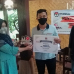 Ketua KPU Banyuwangi Dwi Anggraeni menyerahkan hadiah juara lomba vlog di Ijen Isun Banjarsari, Kecamatan Glagah, Kabupaten Banyuwangi. (foto: ist)
