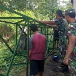 Warga Dusun Buluh Bebe bersama prajurit Kodim 0829/Bangkalan ketika mengangkat kerangka tandon.