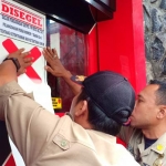 Petugas Satpol PP Blitar memasang sticker segel di Karaoke Maxi Brillian.