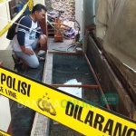 Petugas memasang garis polisi di rumah Erni, warga Perumahan Griya Karya Raharja yang kedapatan memelihara hewan-hewan buas. foto: AKINA/ BANGSAONLINE