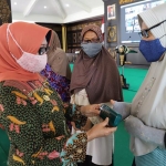 Bupati Jombang Mundjidah Wahab menyerahkan bantuan kacamata kepada perwakilan penerima dari Muslimat dan Aisyiyah.