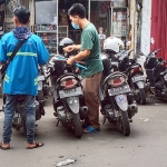 Juru parkir atau jukir di Jalan Samanhudi, Gresik, saat melayani pembayaran. Foto: SYUHUD/BANSAONLINE