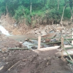 Jembatan kayu hasil swadaya warga sebagai pengganti sementara jembatan yang rusak akibat diterjang banjir