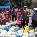 Kapolres AKBP. Bayu Pratama Gubunagi, didampingi Kasatlantas dan jajaran Polsek saat membagikan air bersih kepada warga, Rabu (28/9/2022).