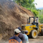 Petugas saat melakukan pembersihan material longsor di Kota Batu. 