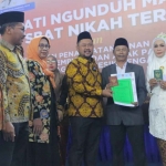 Bupati Gresik, Fandi Akhmad Yani memberikan dokomen nikah kepada peserta sidang isbat. Foto: Ist