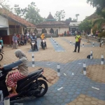 Warga mencoba jalur latihan uji praktik SIM di halaman MI Nurul Huda.