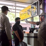 Petugas saat melakukan ukur suhu tubuh terhadap penumpang yang baru turun dari Kereta Api, di Stasiun Kereta Api Kediri. foto: MUJI HARJITA/ BANGSAONLINE