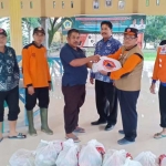 Kepala BPBD Gresik Tarso Sagito (dua dari kanan) menyerahkan bantuan untuk korban banjir.