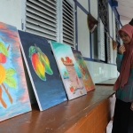 Dua orang siswi SMP Negeri 3 Kediri dengan busana tradisional sedang mengamati lukisan hasil karya kawan-kawannya. Foto: Ist.