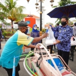 Wali Kota Madiun Maidi saat membagikan nasi kotak kepada salah satu tukang becak.