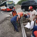 Pekerja sedang memperbaiki rel kereta yang mulai ambles di perlintasan kereta Bandar Kedungmulyo. foto: RONY S/ BANGSAONLINE