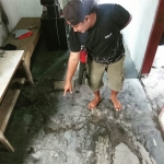 Salah satu warga menunjukkan lantai rumahnya yang retak pasca amblesnya tanggul lumpur Lapindo.