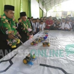 Muhammad Reza Hizbulloh dan Yusron Roziqin (berkalung bunga) saat memperaktikan operasional robot yang dia bawa bertarung ke luar negeri. foto: RONY S/ BANGSAONLINE