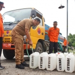 Pjs. Bupati Kediri Heru Wahono Santoso, saat ikut mengisi air ke jirigen. (Ist)