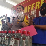 BARANG BUKTI: Kapolres Bojonegoro AKBP Ary Fadli menunjukkan vodka KW yang disita dari tersangka.
