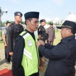 Bupati Muhtarom menyematkan tanda peserta dalam apel besar Marka Jalan.