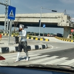 Salah satu manusia silver tampak sedang meminta-minta di Traffic Light Exit Tol Kebomas. foto: SYUHUD/ BANGSAONLINE
