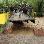 Jembatan di Kelurahan Kowel putus diterjang arus Sungai Klowang yang sangat deras. (foto: ist)