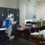 Petugas BPBD Gresik saat melakukan penyemprotan disinfektan di Kantor DPMD. foto: SYUHUD/ BANGSAONLINE