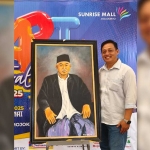 Anggota DPRD Kabupaten Mojokerto dari Fraksi NasDem, Hery Suyatnoko, di samping lukisan Kiai Asep.