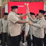 Sekretaris DPD PKDI Jawa Timur Sandy (kiri) saat memberikan bendera pataka kepada ketua DPC PKDI Bangkalan, H. Marhayat.