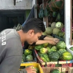 Salah satu warga tengah membeli buah blewah di Pasar Tradisional Tanjung, Jember.