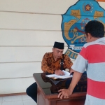 Ketua Komisi A DPRD Bangkalan Mujiburrahman (duduk) ketika mengecek absensi di Kantor Kecamatan Arosbaya. foto: FAUZI/ BANGSAONLINE