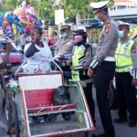 Kasatlantas Polres Sampang AKP Ayip Rizal saat mebagikan sembako kepada tukang becak.