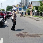 Petugas usai menutupi jalan bekas darah korban dengan pasir.