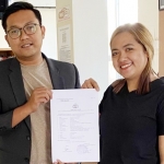 Foni Oktavia Diansari (kanan) didampingi kuasa hukumnya, Rikza Teguh Dwi Marza, menerima tanda bukti Lapor Polisi.