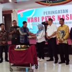 Wakil Bupati Ngawi Dwi Riyanto Jatmiko saat menerima tumpeng dari Ketua PWI Ngawi Kundari Prisusanti.