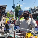 Petugas Satlantas Polres Ngawi saat membagikan bingkisan paket sembako ke Pengemudi Becak.