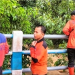 Petugas BPBD Pamekasan mengamati sungai untuk mencari keberadaan korban.
