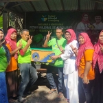 Bunda Indah saat menerima hasil panen pisang cavendish dari para petani. Foto: IMRON GHOZALI/ BANGSAONLINE
