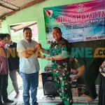 Wakil Ketua DPRD Gresik, Mujid Riduan, saat memberi potongan tumpeng kepada Danramil 0817/03 Kedamean, Kapten Inf M. Zainudin. Foto: SYUHUD/BANGSAONLINE