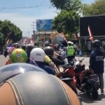 Anggota Polresta Banyuwangi bersama warga sedang mengheningkan cipta di Simpang Lima.
