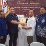 Ketua DPD Nasdem Gresik Syaiful Anwar menyerahkan berkas pendaftaran kepada Ketua KPU Gresik Achmad Roni. Foto: SYUHUD/ BANGSAONLINE