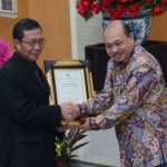 Bupati Tuban saat menerima penghargaan Swasti Saba Padapa dari Staf Ahli Bidang Desentralisasi Kesehatan, dr Pattiselanno Roberth Johan.