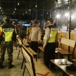 Petugas gabungan sedang menertibkan salah satu kafe/warkop yang masih buka di atas batas jam malam. 