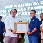 Wartawan HARIAN BANGSA, Yudi Arianto, saat menerima piagam penghargaan dan trofi dari Wali Kota Surabaya, Eri Cahyadi. Foto: Ist