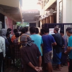 Masyarakat yang berkerumun d depan masjid menunggu pembagian nasi bungkus.