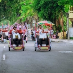 Bupati Gresik Fandi Akhmad Yani dan Wabup Asluchul Alif dengan naik becak listrik  kirab Adipura. foto: ist.